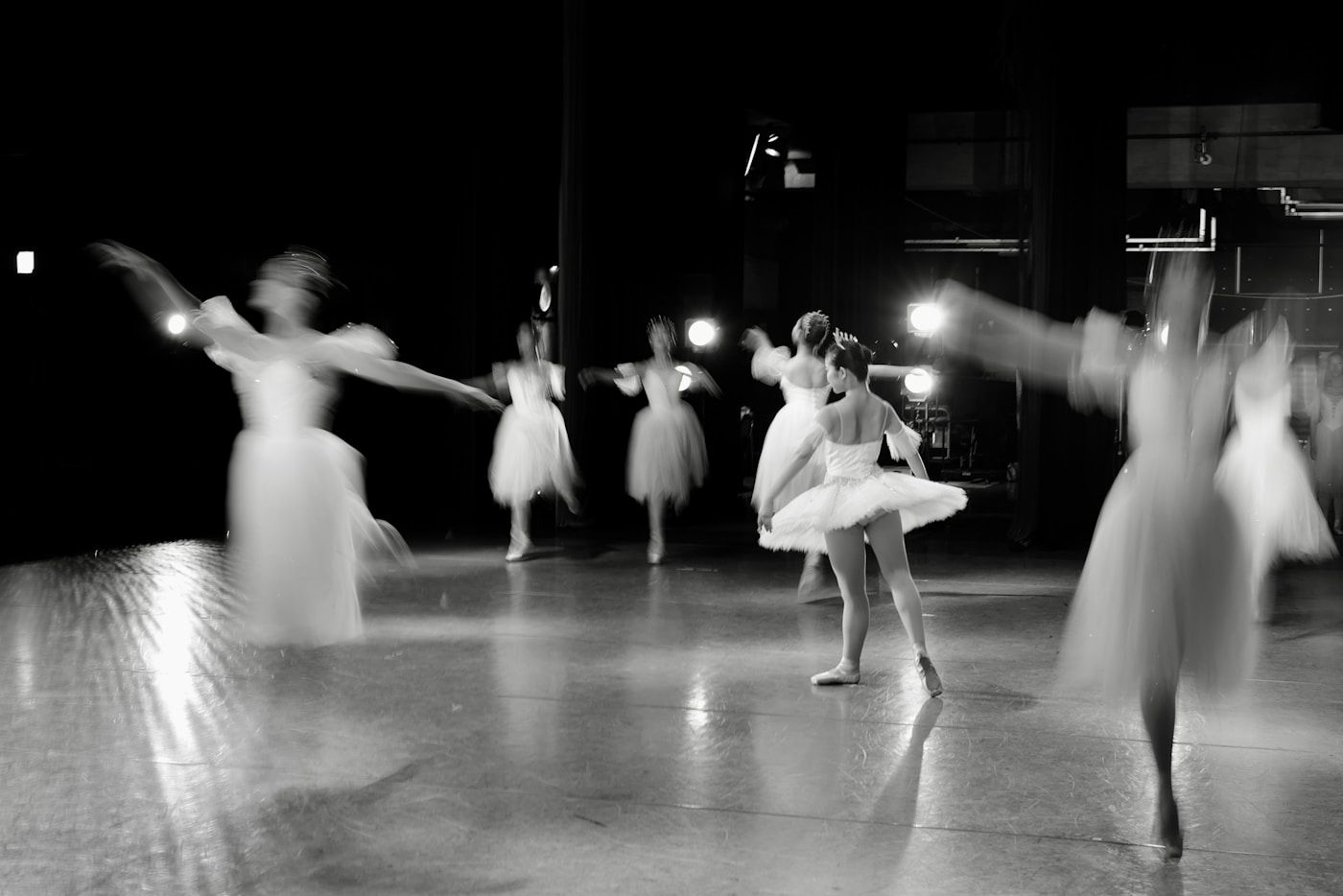 Une danseuse répétant sous les lumières de la scène
